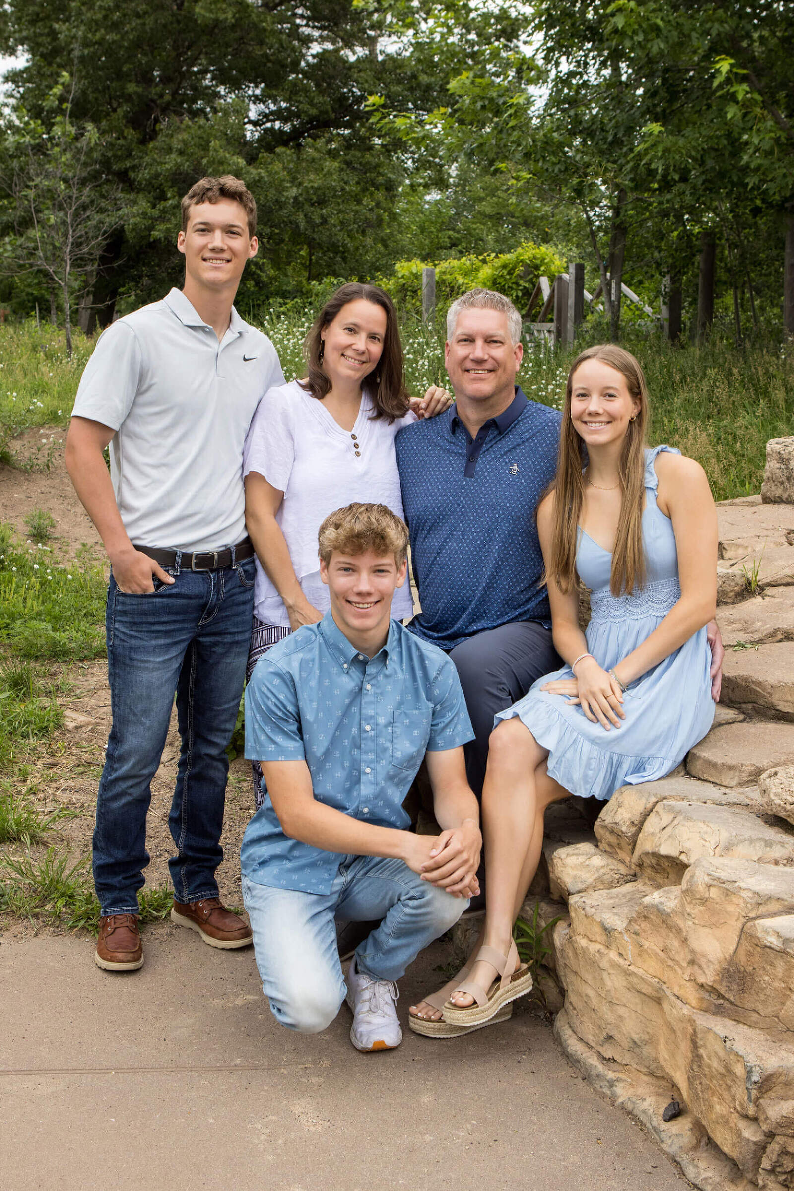A family of five poses for a an outdoor family session.