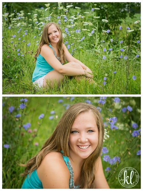 A teen girl sitting in tall grass in front of purple flowers.