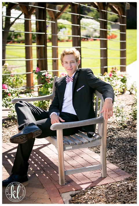 Teen boy shows off his preppy style by wearing a black suit for his senior photos with Littleton photographer Kristina Lynn Photography & Design