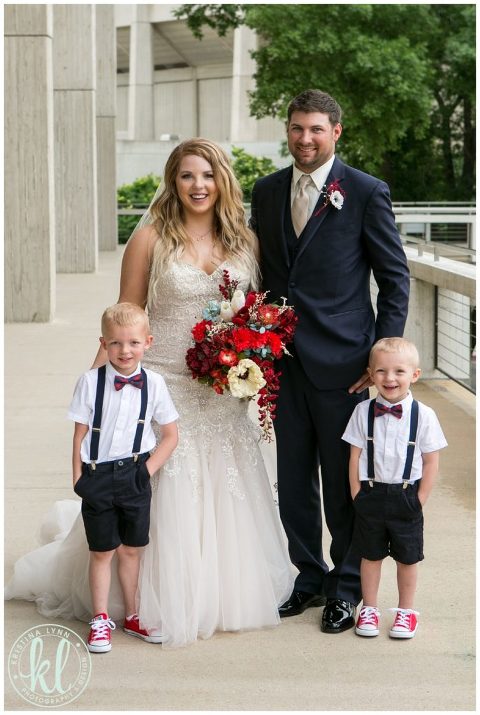 Bride and groom pose with their ring bearers on their wedding day.