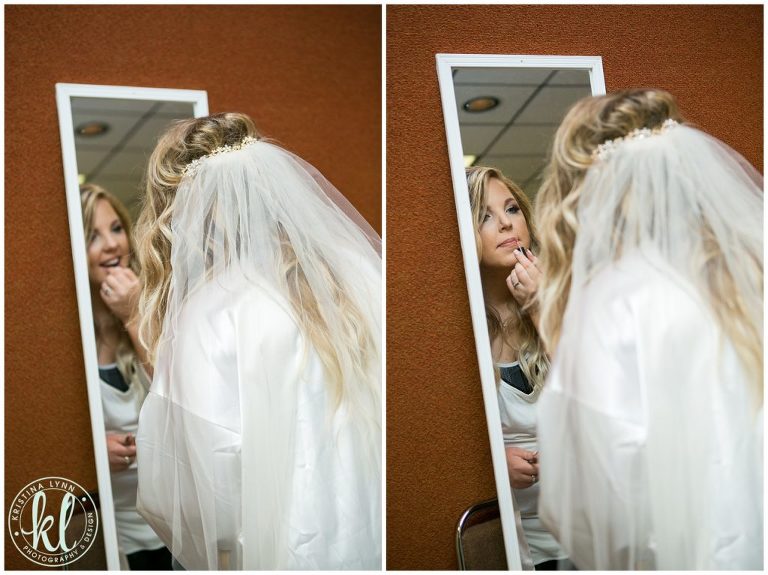 The bride touches up her makeup on her wedding day at the Scheman Building in Ames Iowa.
