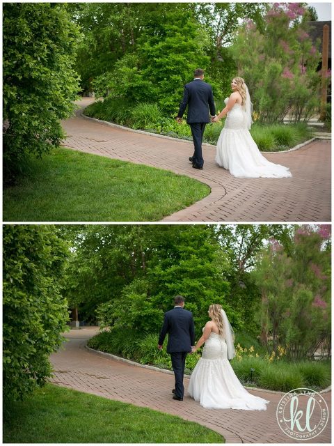 Bride and groom take a stroll on a path at Reiman Gardens in Ames Iowa on their wedding day.
