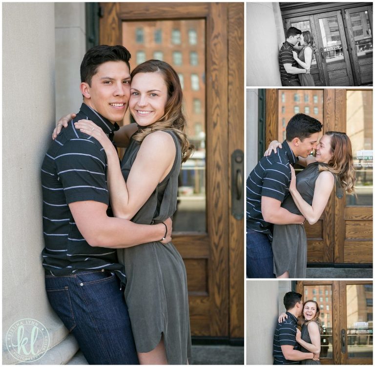 Engaged couple in front of a wooden door in an urban setting during their engagement photos session.