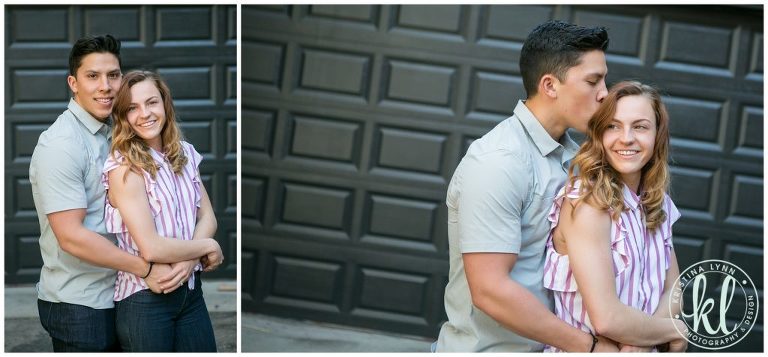 Guy wraps his arms around his girl and kisses her on the head.