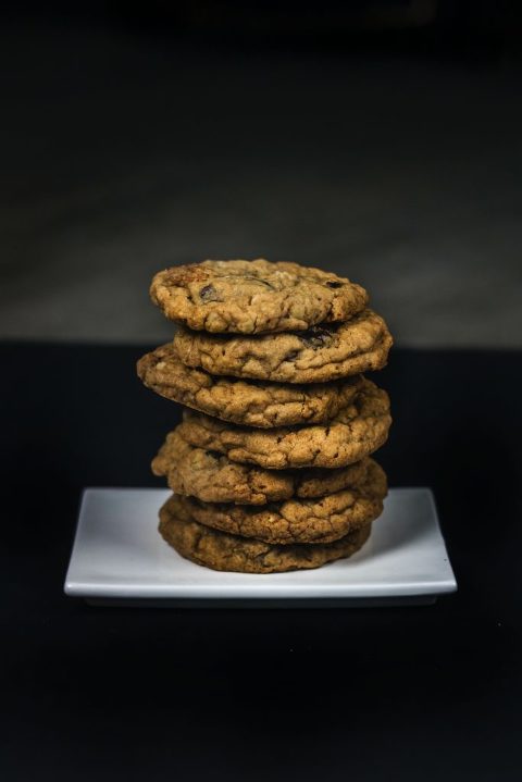 Product photography of a stack of oatmeal raisin cookies on a plate.
