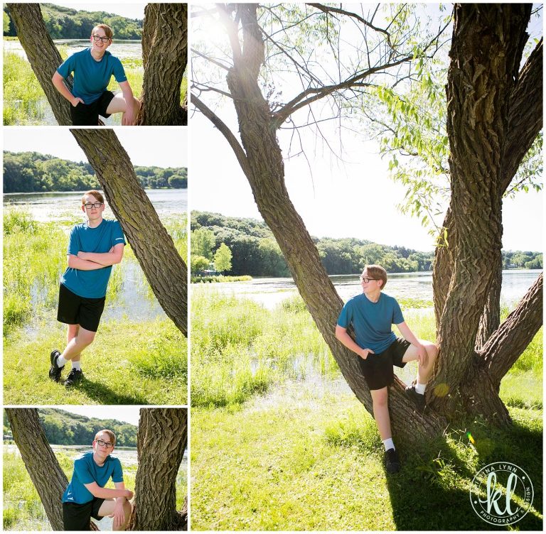 teenage boy standing by a tree in a lakeside park in stillwater minnesota