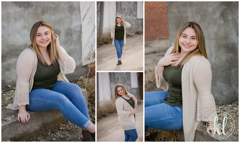 high school senior girl wearing cream colored cardigan poses for photos in an alleyway