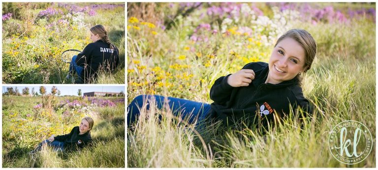 teenager girl laying in wildflower field in wisconsin during senior portraits session