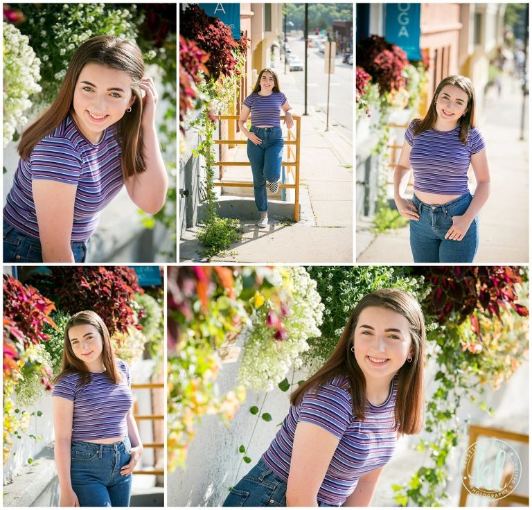 teen girl poses for graduation pictures by colorful flowers in downtown stillwater minnesota