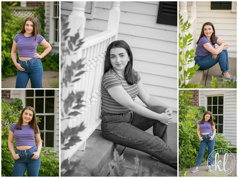 teenage girl sits on a curb outside white building for senior pictures in downtown stillwater