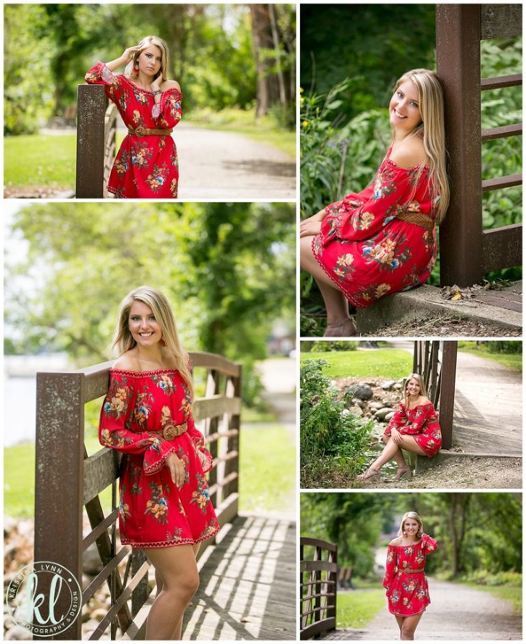 high school senior girl wearing a red dress poses on bridge at lake cornelia park near clarion iowa