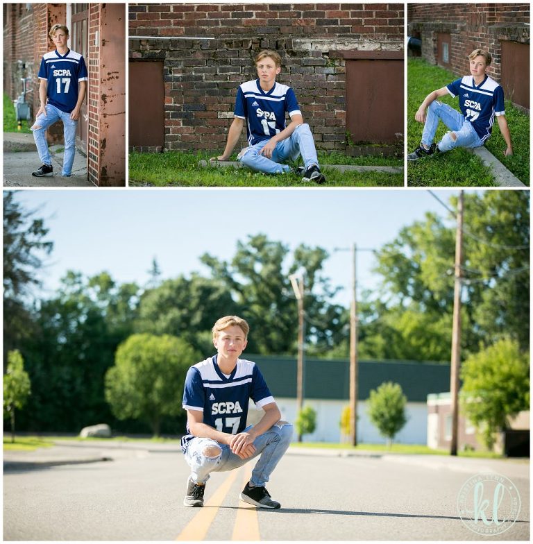 senior pictures of a teen in soccer jersey by a brick wall
