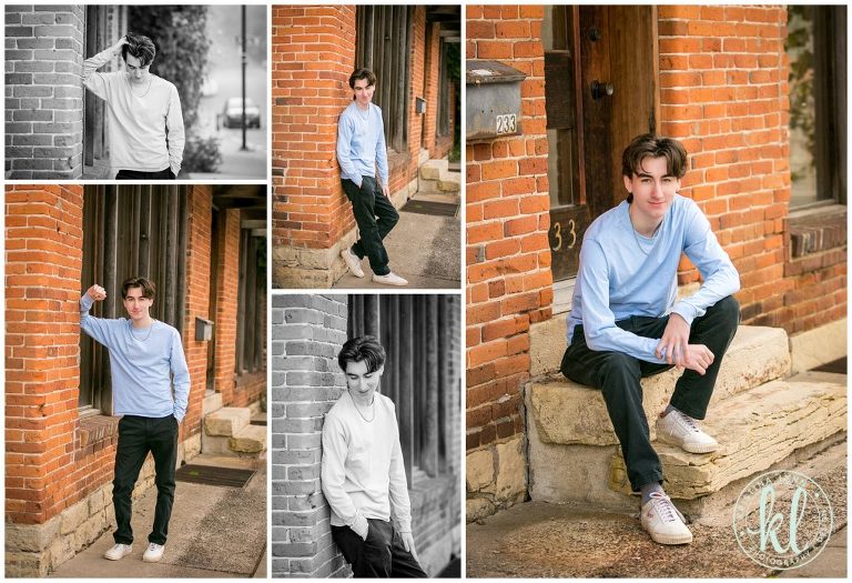 teenage guy posing next to brick building for senior pictures in stillwater minnesota