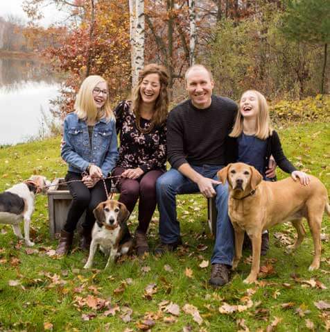 An outdoor family photo featuring mom, dad, 2 daughters and 3 dogs done by Kristina Lynn Photography during a Fall Session in Minnesota.
