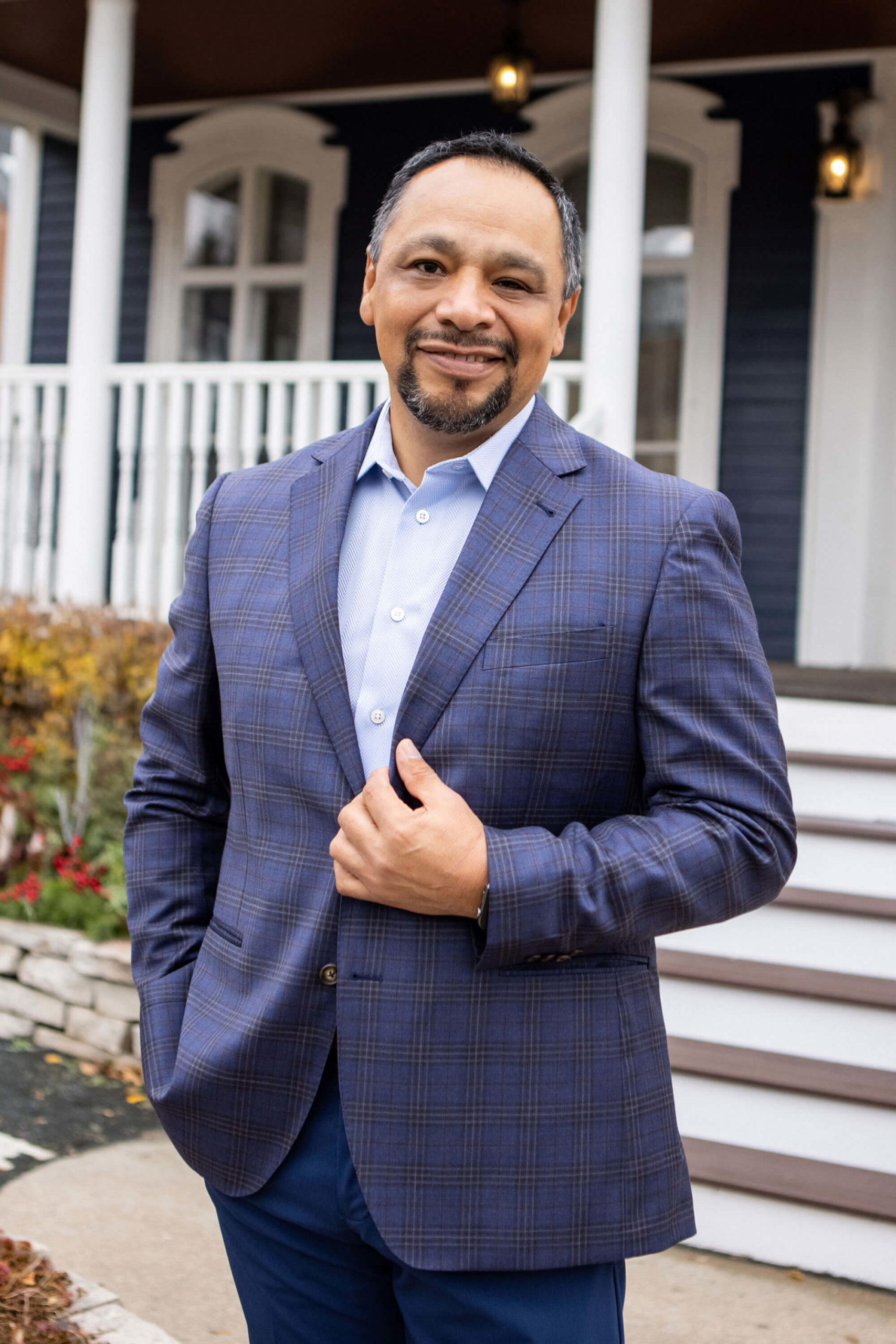 Business man in blue suit outside of a blue house poses for Headshot Photographer Kristina Lynn of KLPD Kristina Lynn Photography & Design